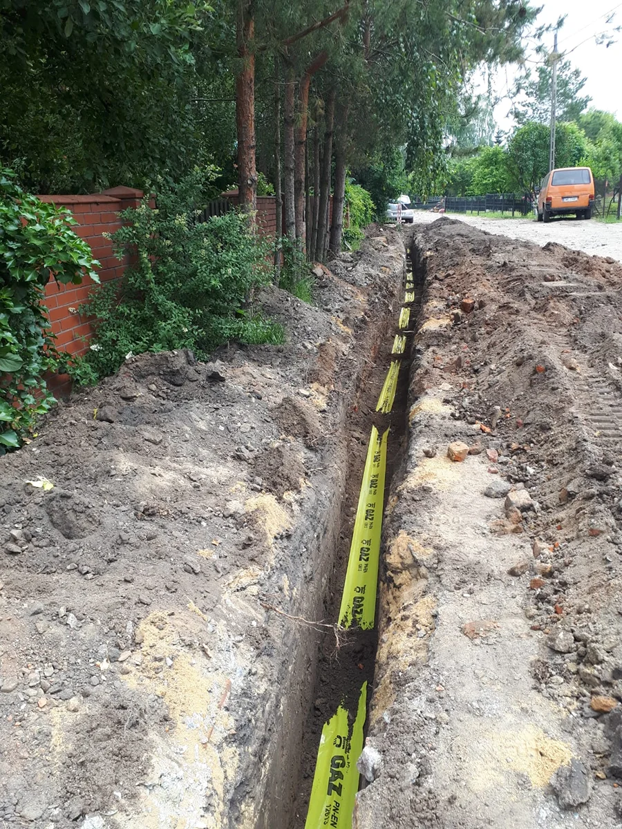 Przewiert podziemny kretem z rurą osłonową wciąganą pod podjazdem